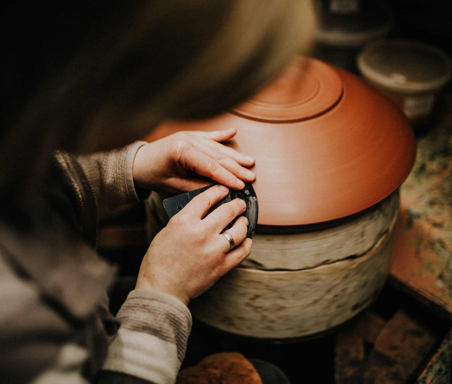 Polishing the outside of a clay bowl