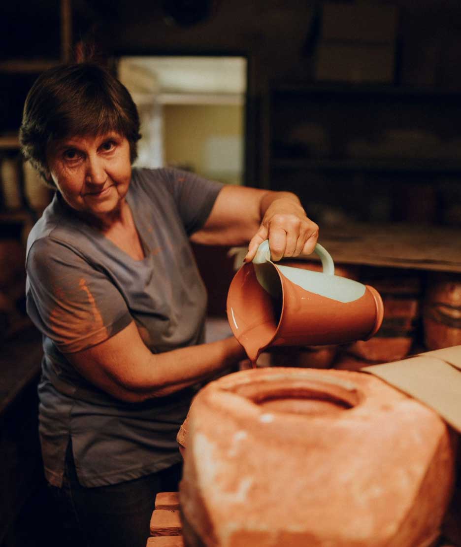 Potter glazing the inside of a bowl